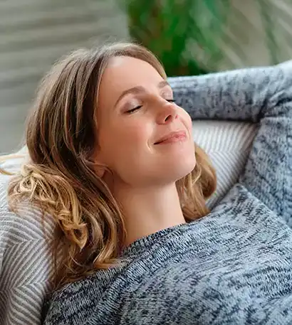 Jeune femme avec sourire sur un divan
