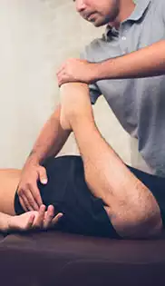 Etirement d'une jambe par un masseur