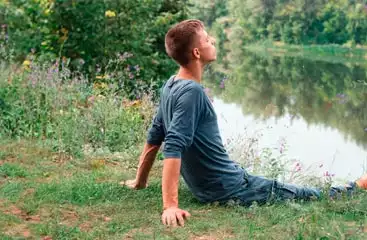 Jeune homme assis bord de rivière