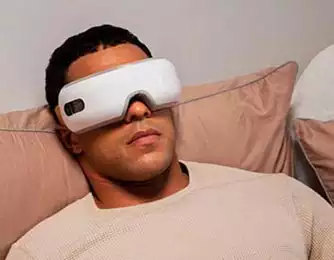 Homme se relaxant avec une paire de lunettes de massage