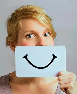 Visage d'une jeune fille avec un sourire sur un carton devant elle