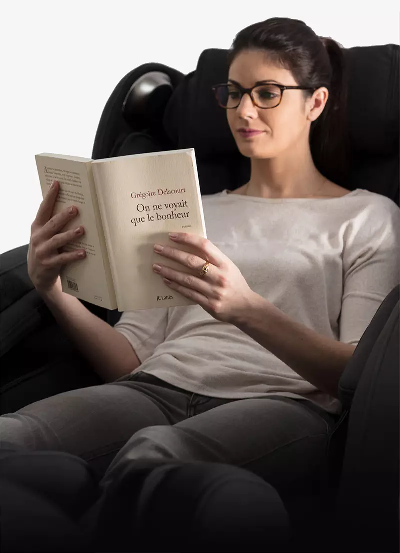 Femme qui lit assise dans un fauteuil de massage Evasion 3D